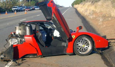 crashed red ferarri with it's door open lifted up
