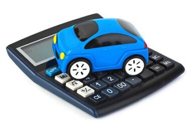 Calculator with small blue toy car sitting on top