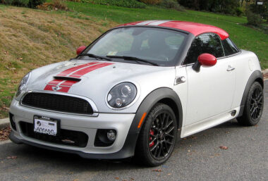 Mini Coupe with red racing stripes parked outside