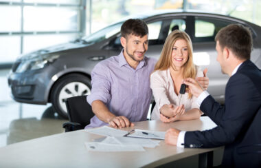 Two people buying a car in a showroom