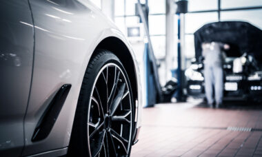 Front wheel of white car in a repair garage