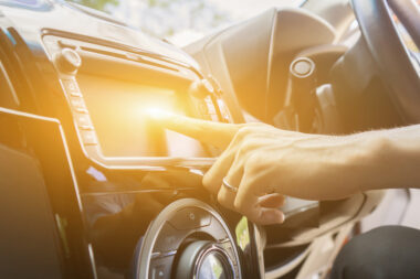 Hand on a touchscreen inside a car