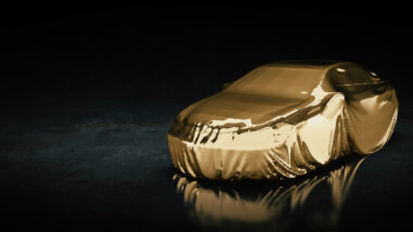 Image of a car wrapped in a gold cloth on a black background