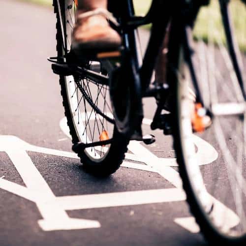 Low photo of a bike riding across a road painting of a cycle lane