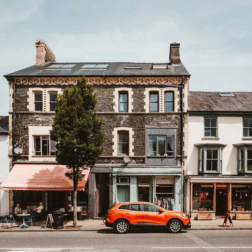 Car parked outside of a small shop