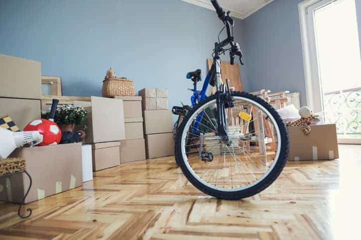 A bicycle is being stored inside while the residents unpack their belongings into their new home. 