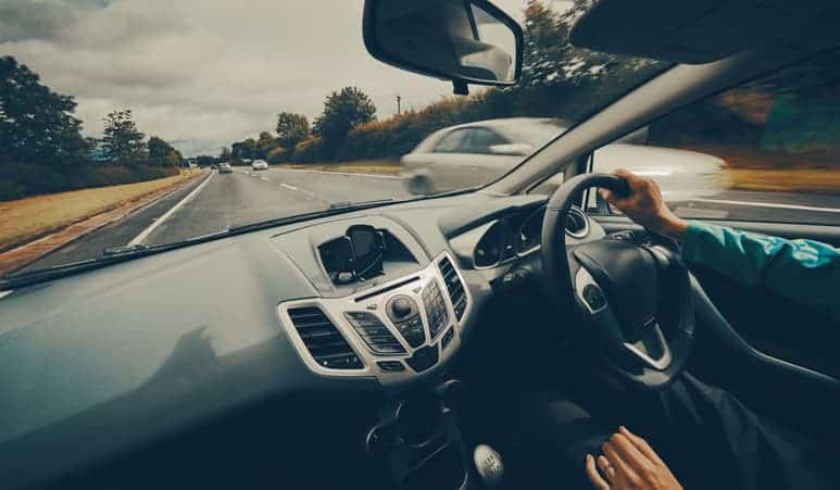 A female driver driving a car along a busy road