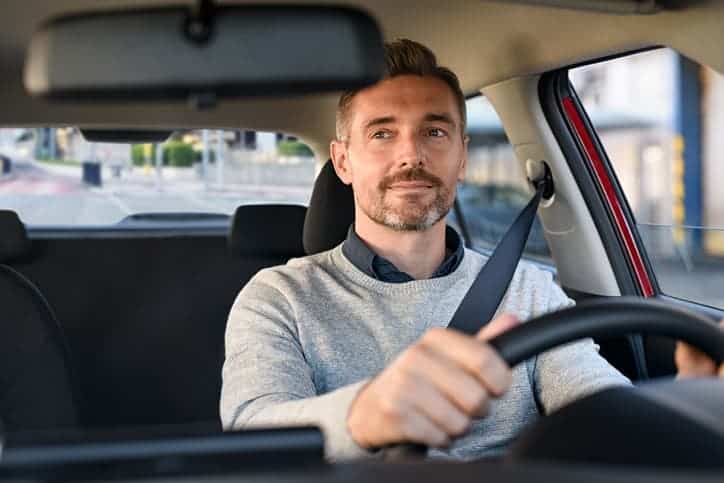 Happy man driving a new car