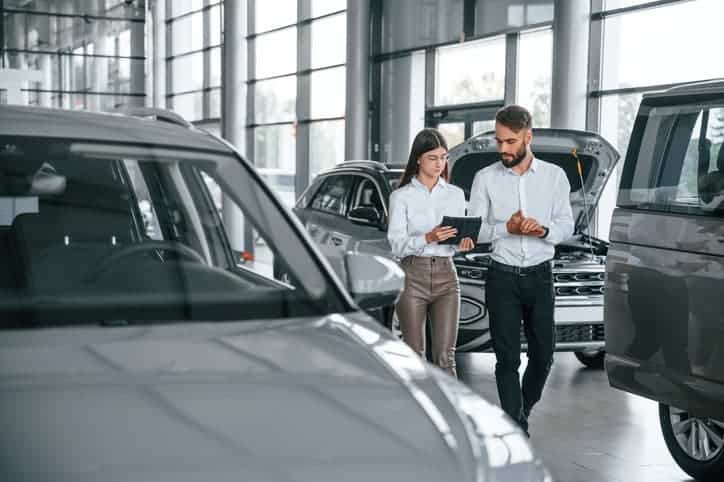 2 people in a car dealership