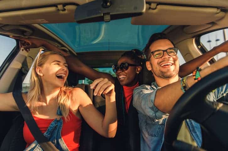 Three best friends enjoying traveling at vacation in the car