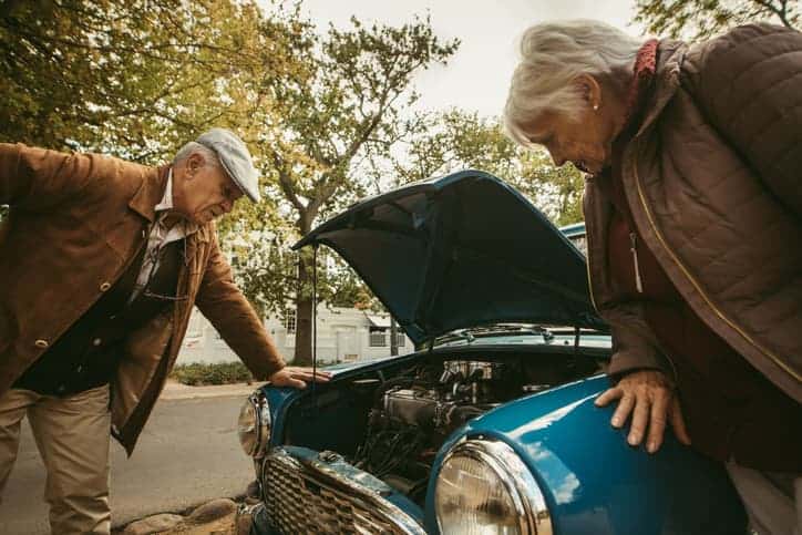 Senior couple stranded on road with broken car
